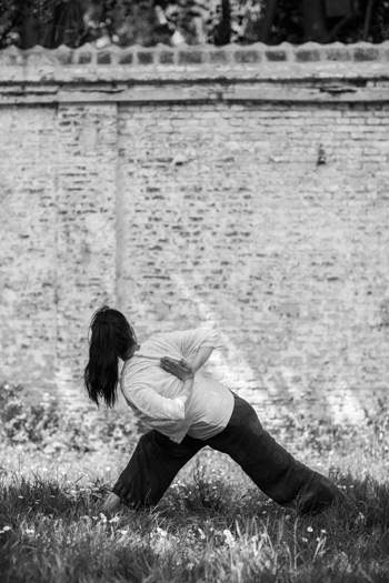 Derde yoga pose voor een stenen muur in Gent